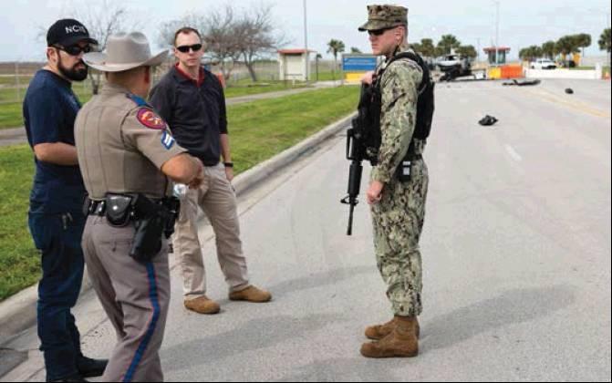 U.S. Navy Security Forces, Naval Criminal Investigative Service, and Texas Department of Safety personnel discuss an incident involving a vehicle unlawfully entering the base, Feb. 14. Navy Security Forces personnel opened fire after the suspect crashed h